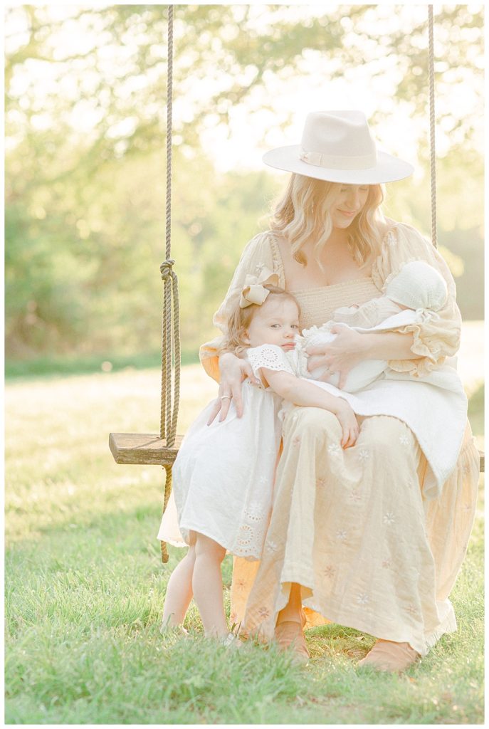 Huntsville Motherhood Photographer, mom looking at baby girl while swinging and hugging toddler girl