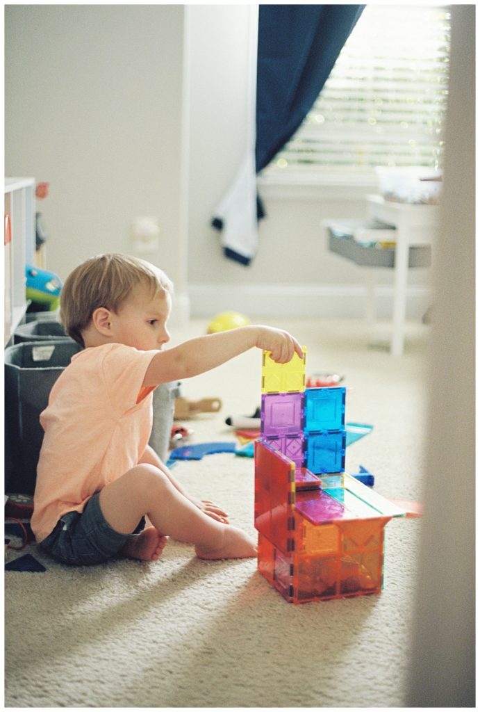 Morning rhythms with young children, little boy playing with magnatiles