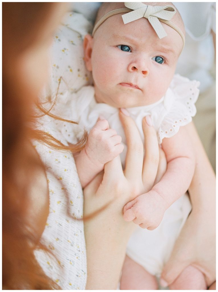 baby girl holding mother's finger