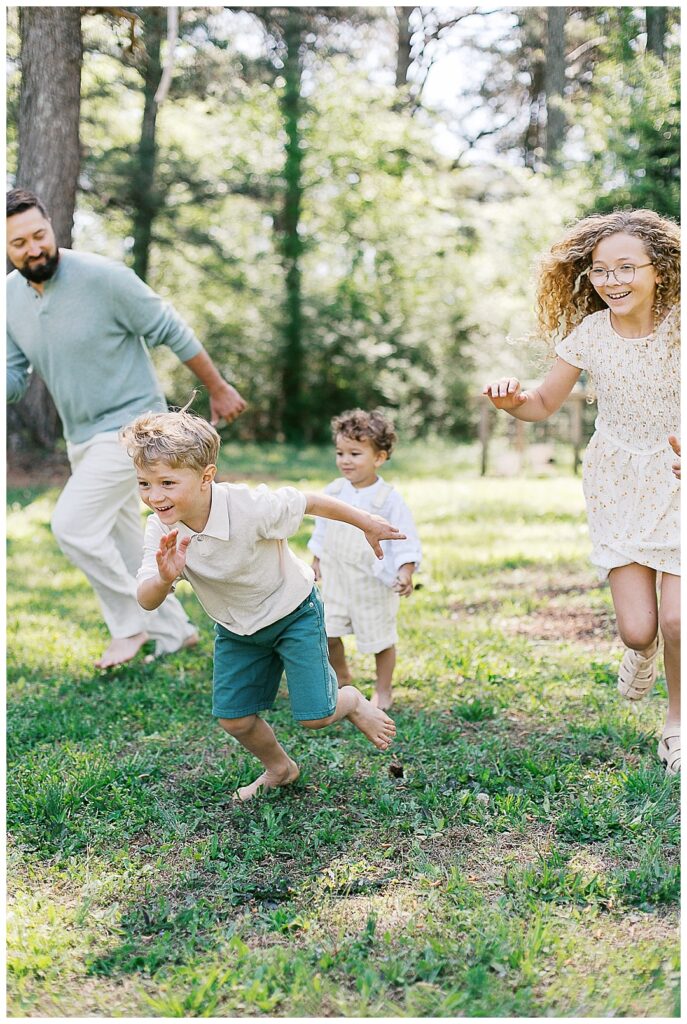 backyard ideas for your in-home family session in huntsville, family of four playing chase in bare feet and spring clothes