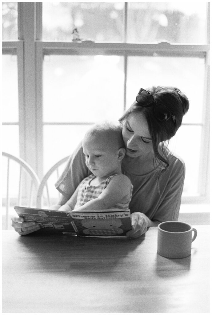 black and white ideas for your in-home family session, mom reading books with her baby and drinking coffee