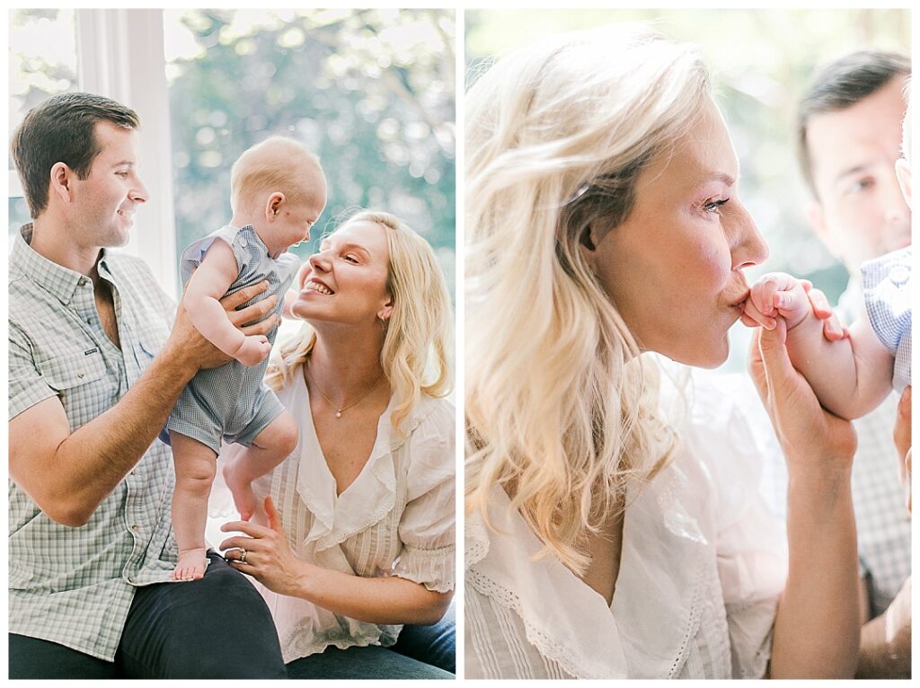 family of three smiling and kissing baby hand
